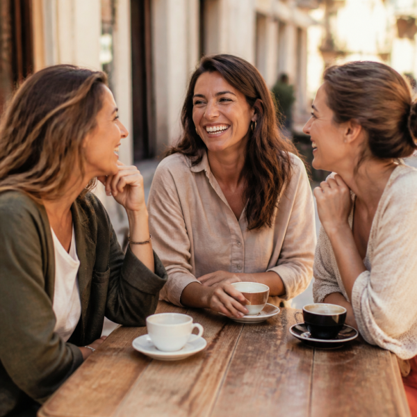 Adults talking and laughing together at an outdoor cafe